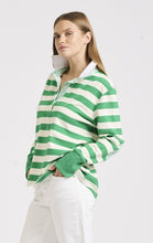 Load image into Gallery viewer, Sporty year-round style. This model looks great in our green and white striped rugby jumper, proving it&#39;s a versatile piece for any season. The breathable cotton and relaxed fit make it perfect for layering, while the contrasting elbow patches, collar stand and front placket add a point of difference.
