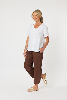 A white V Neck linen short sleeve top with curved hemline, frill trim around the neckline, front placket and sleeve cuff.